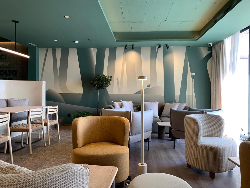 a waiting area with chairs and tables in a room at CIM HOTEL BOUTIQUE in Puigcerdà