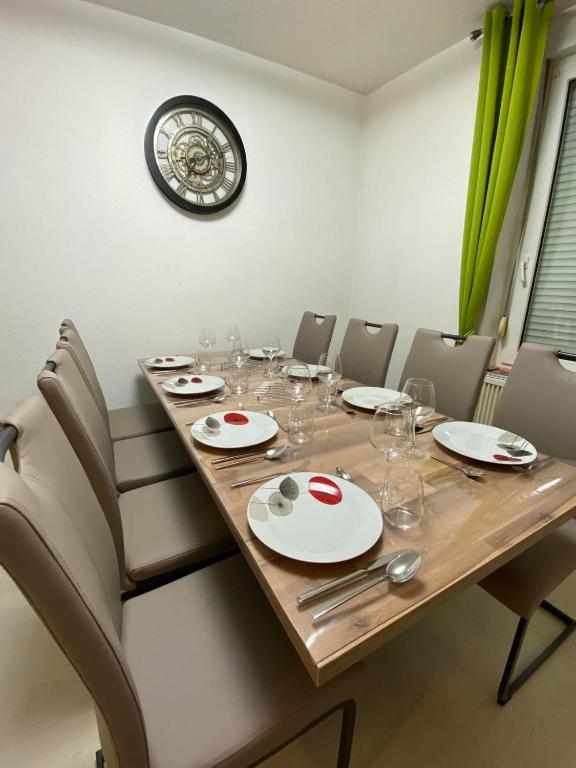 une table à manger avec des chaises et une horloge murale dans l'établissement Grand'Roche, à Cornimont