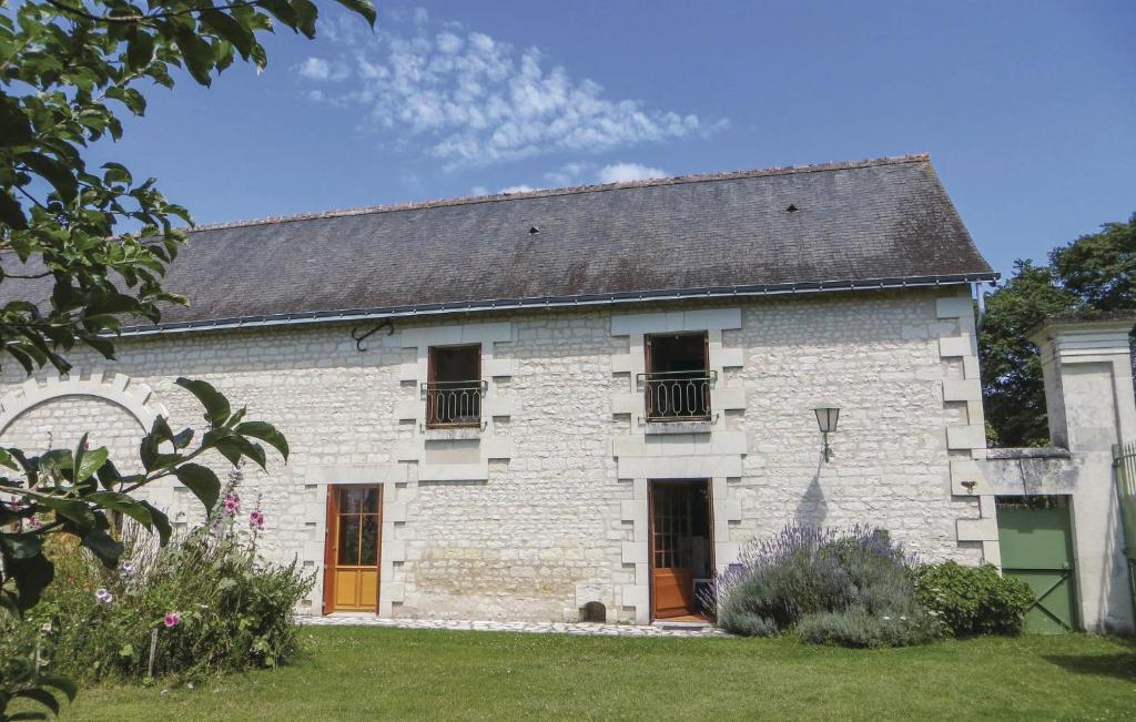 a white brick house with a black roof at Le Clos Des Tilleuls in Ligré