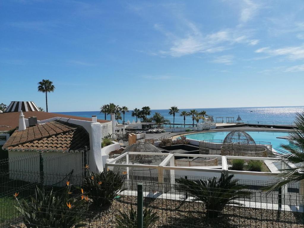 Una vista de un resort con piscina y el océano. en Villa 88, en Almancil