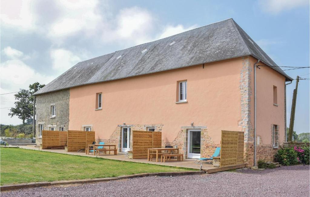 a large pink house with chairs and a table at 3 Bedroom Stunning Home In Sainteny in Sainteny