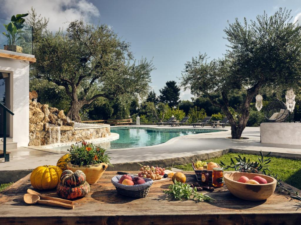 Villa Castelletto heated pool jacuzzi في Kypseli: طاولة عليها فواكه وخضار بجانب مسبح
