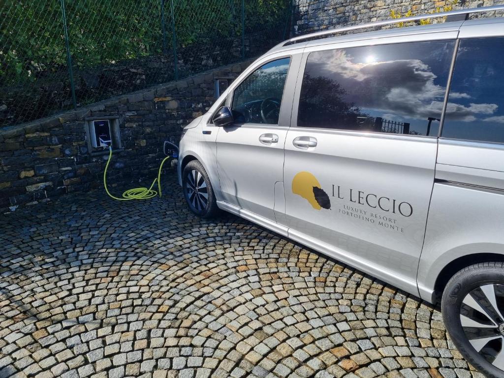 a white van parked next to a wall with a hose at Il Leccio - Luxury Resort Portofino Monte in Santa Margherita Ligure