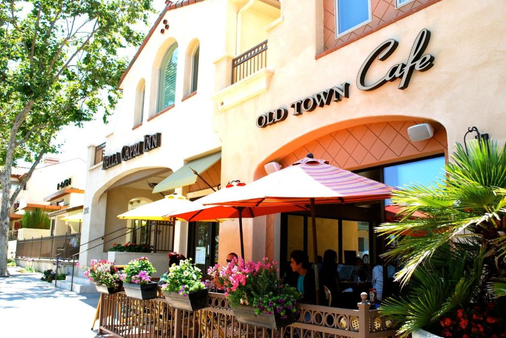 un restaurant avec un parasol en face d'un bâtiment dans l'établissement Bella Capri Inn and Suites, à Camarillo