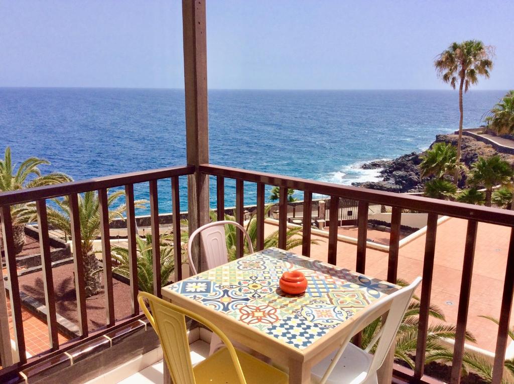 - stół i krzesła na balkonie z widokiem na ocean w obiekcie Apartment With Ocean Terrace w mieście Costa Del Silencio