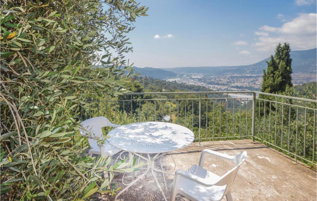 einen Tisch und Stühle auf einem Balkon mit Aussicht in der Unterkunft Cozy Apartment In Castagniers With House A Mountain View in Porcio