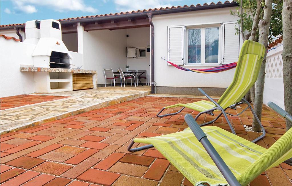 a patio with two lawn chairs and a grill at Stunning Home In Barbariga With Wifi in Barbariga