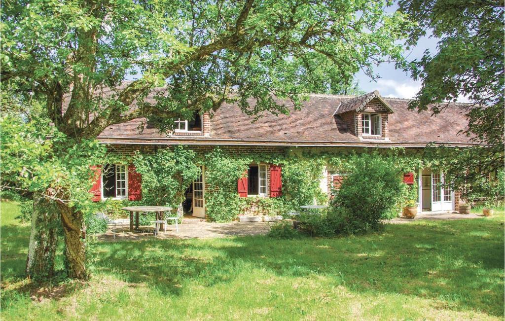 une maison couverte de lierre avec une table de pique-nique dans la cour dans l'établissement Cozy Home In Beauchene With Wifi, à Beauchêne