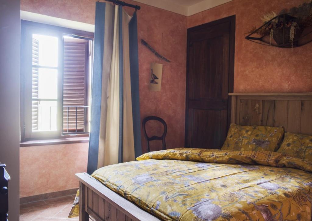 sypialnia z łóżkiem i oknem w obiekcie La Bugia del Sensale w mieście San Donato in Poggio