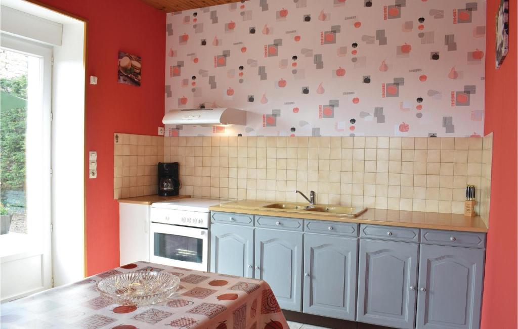 a kitchen with red walls and a sink and a table at Nice Home In Canchy With Kitchen in Canchy