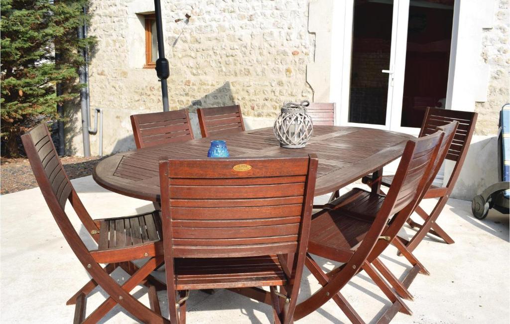 a wooden table with chairs and a vase on it at Nice Home In Canchy With Kitchen in Canchy