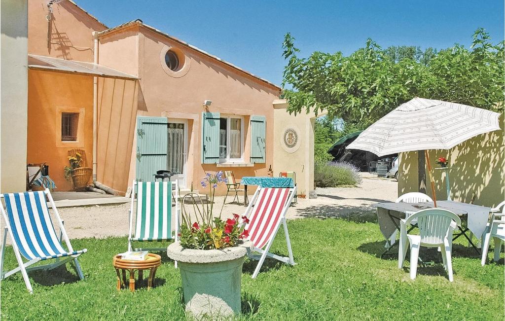 un grupo de sillas y un paraguas en un patio en 1 Bedroom Stunning Home In Caderousse, en Caderousse