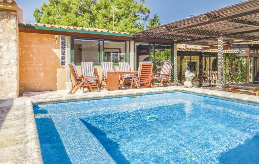 マナコルにあるBeautiful Home In Manacor With Swimming Poolのスイミングプール(椅子、テーブル付)、