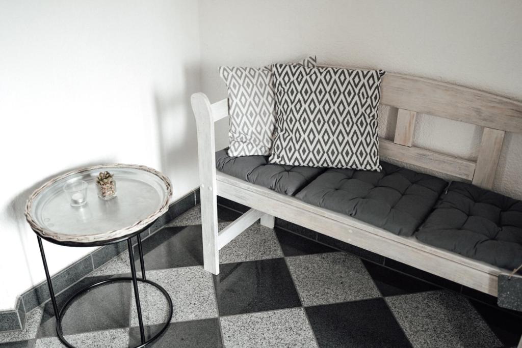 um banco com almofadas e uma mesa num quarto em Ferienwohnung Brennten em Tuttlingen