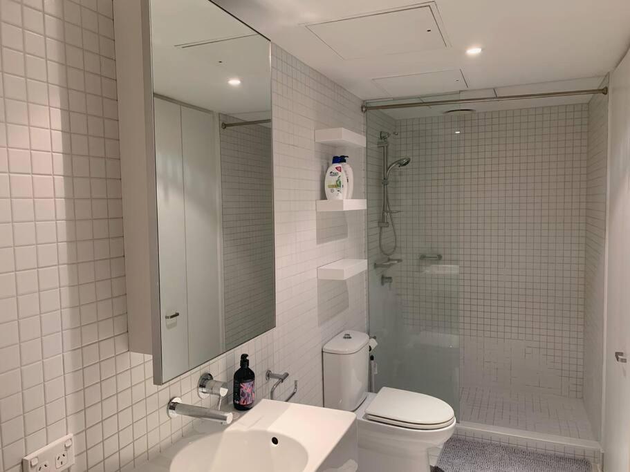 a bathroom with a toilet and a sink and a shower at Light-filled apartment in a dream location 150m away from University of Melbourne in Melbourne