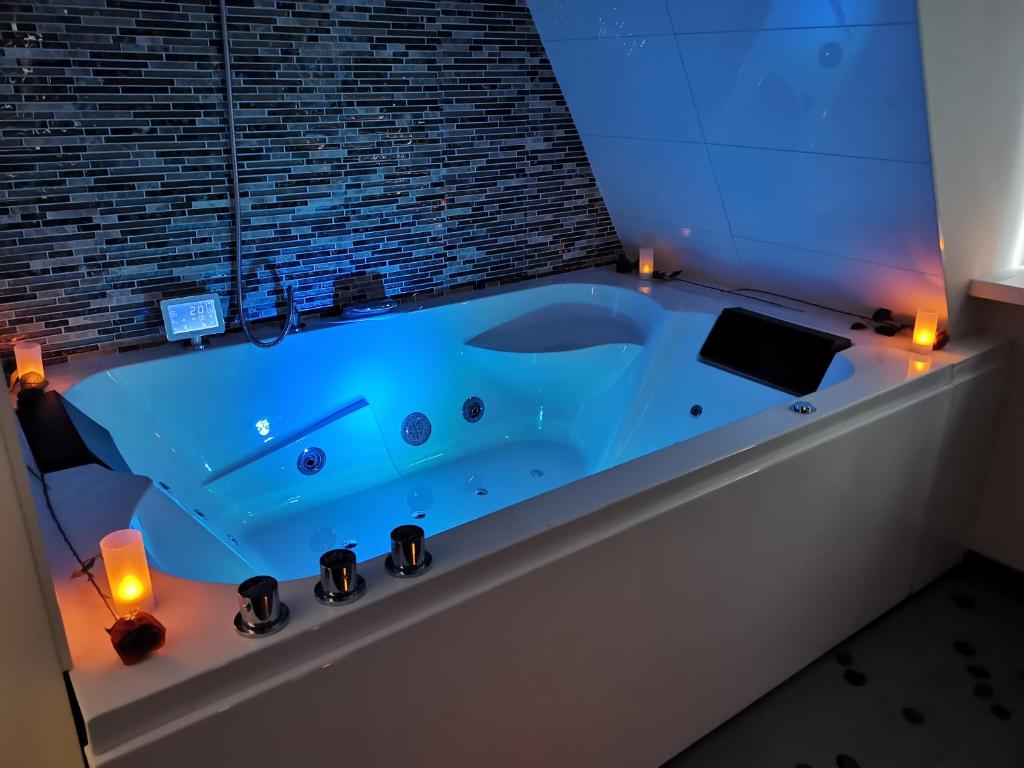 un baño con una bañera azul con velas. en Wellness Suite Utrecht en Utrecht