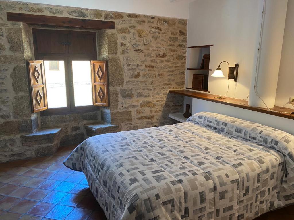 1 dormitorio con cama y ventana en CASA MIRIAM en La Iglesuela del Cid