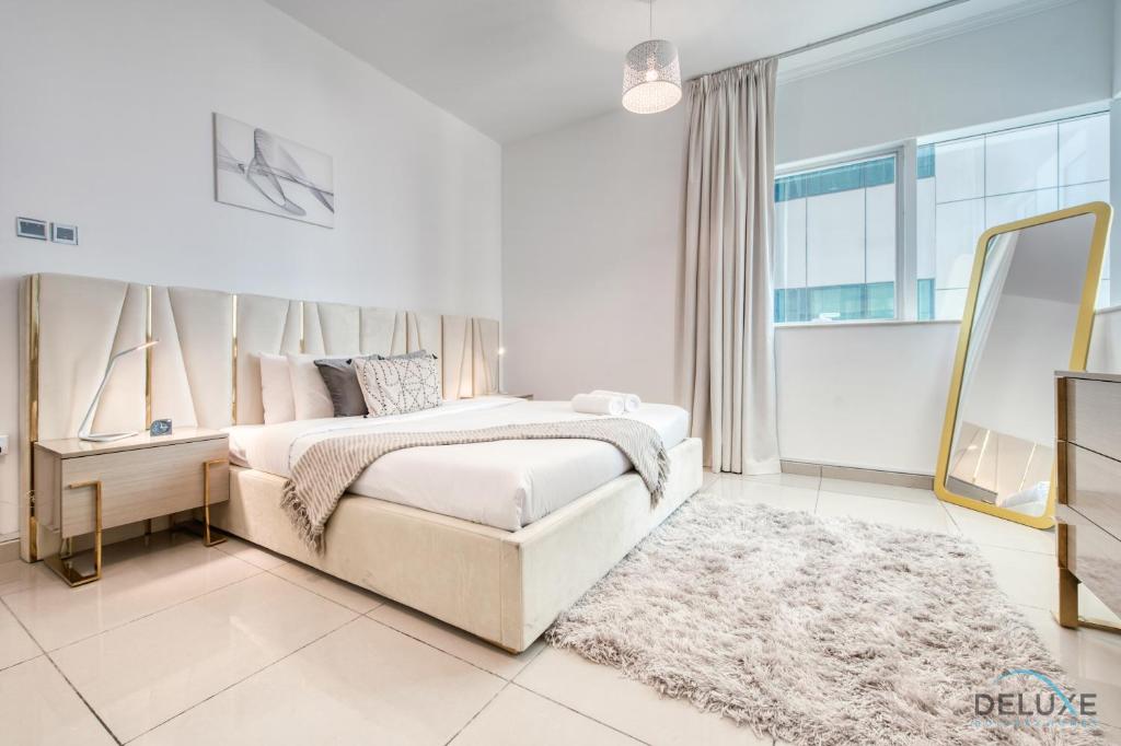 a bedroom with a large bed and a mirror at Dreamy 2BR at Marina Pinnacle Dubai Marina by Deluxe Holiday Homes in Dubai