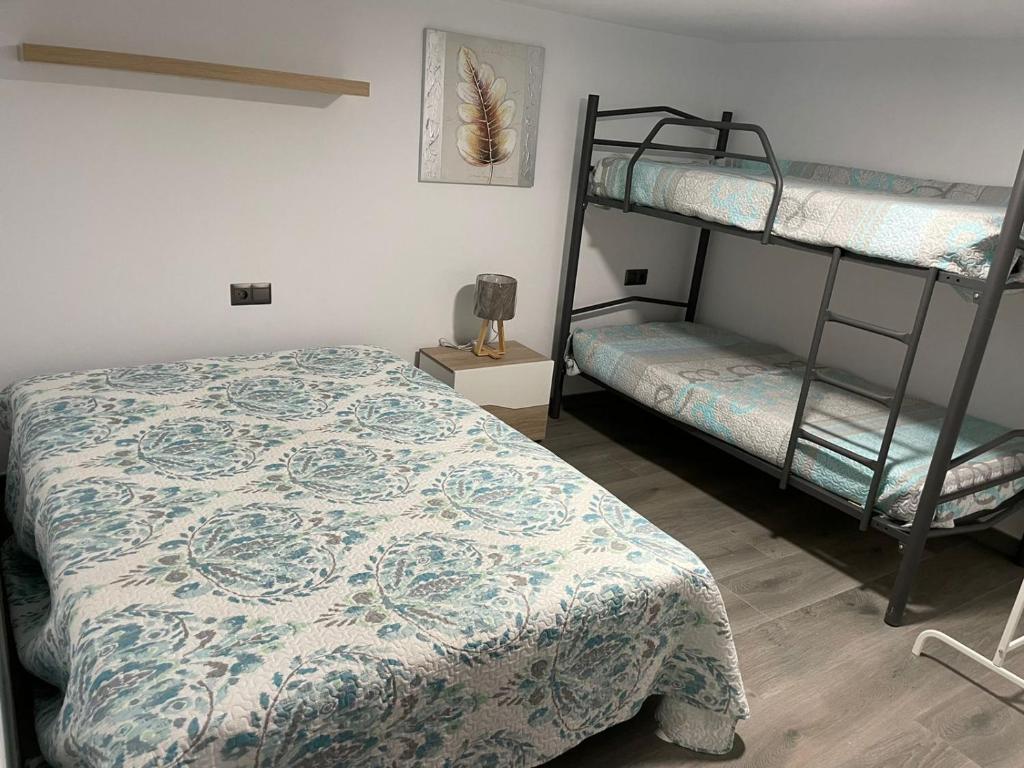 a bedroom with two bunk beds and a bedspread at MONTE AZUL in Málaga