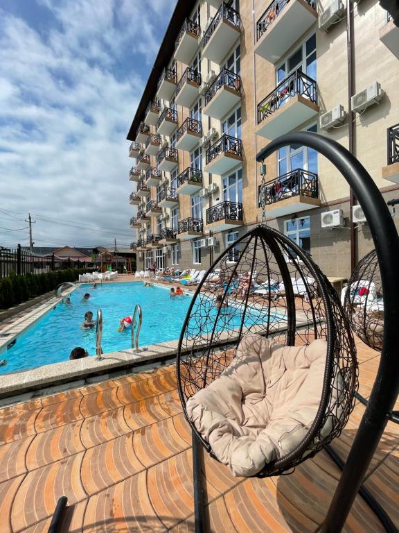 a swing in front of a swimming pool at Отель Империя in Gagra