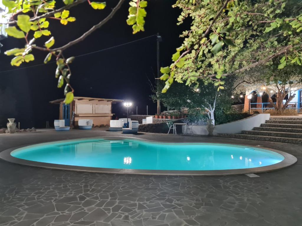 a pool in the middle of a patio at night at Turismo Rurale Filieri in Dorgali