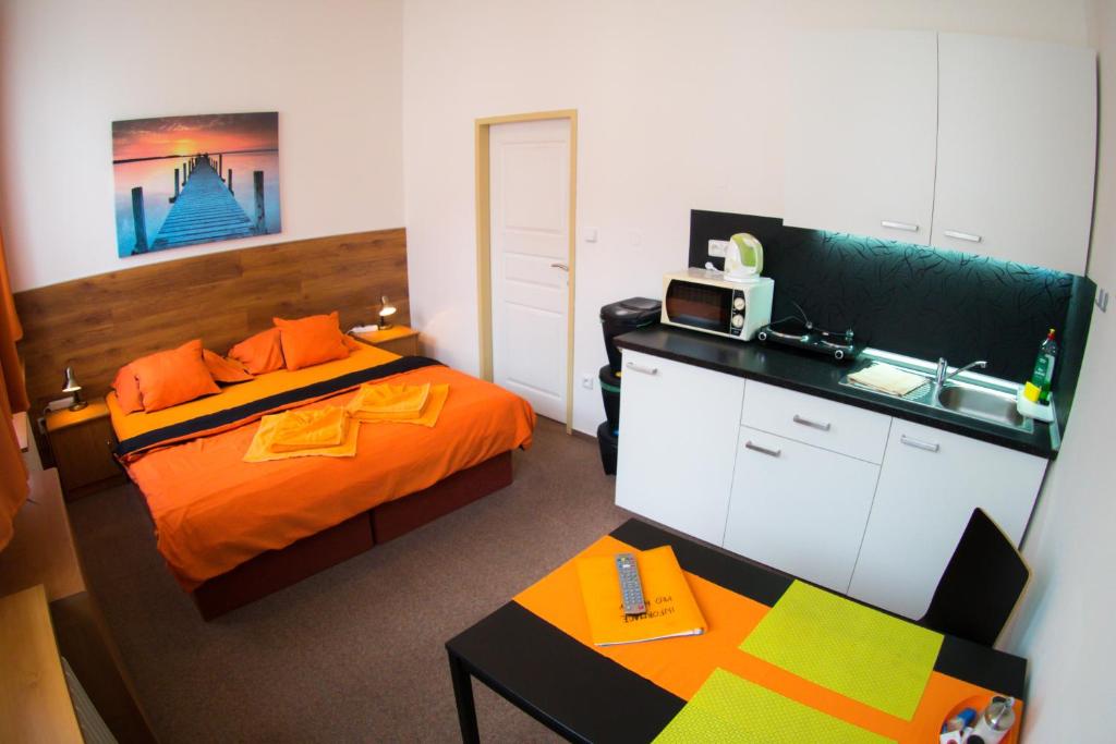 een kamer met 2 bedden en een keuken met een wastafel bij Apartments Radka in Třeboň