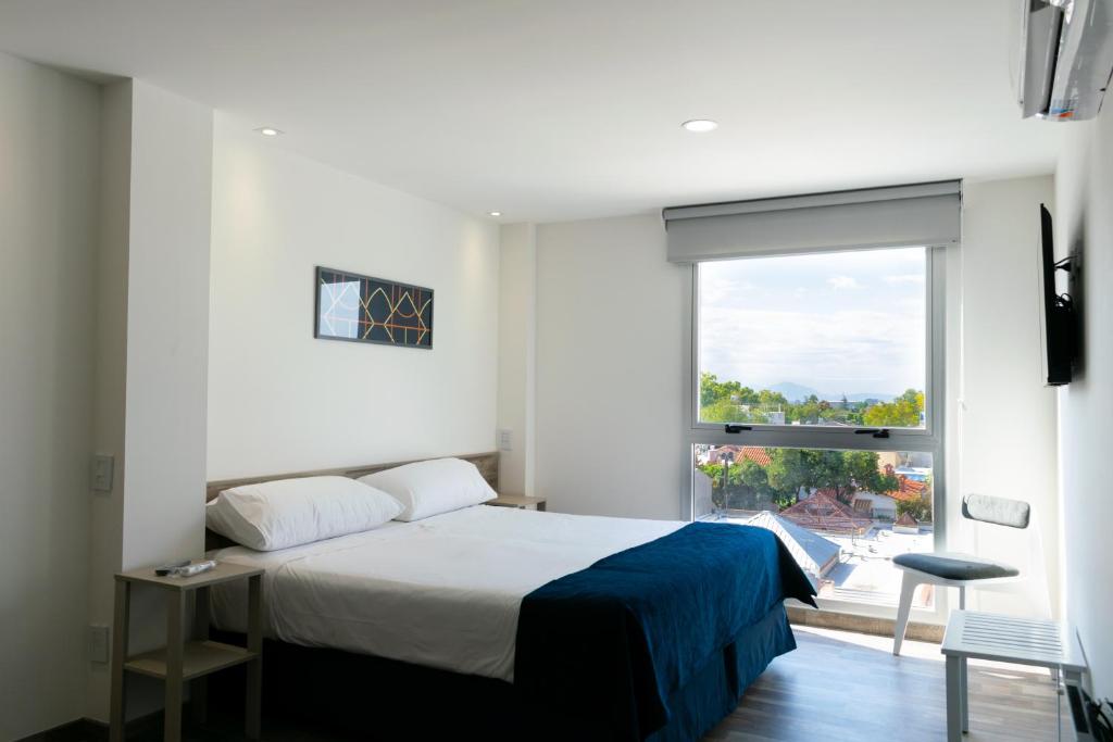 a bedroom with a bed and a large window at Cinco Soles in Godoy Cruz