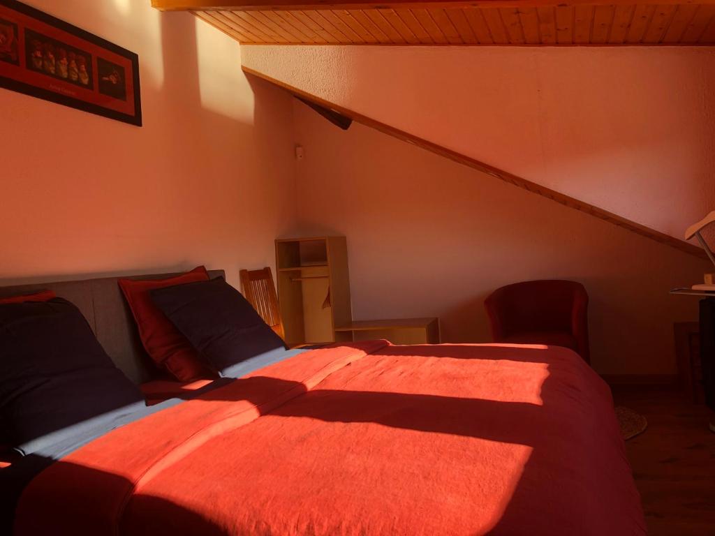 1 dormitorio con 1 cama con manta naranja en La maison bleue, en Altenbach
