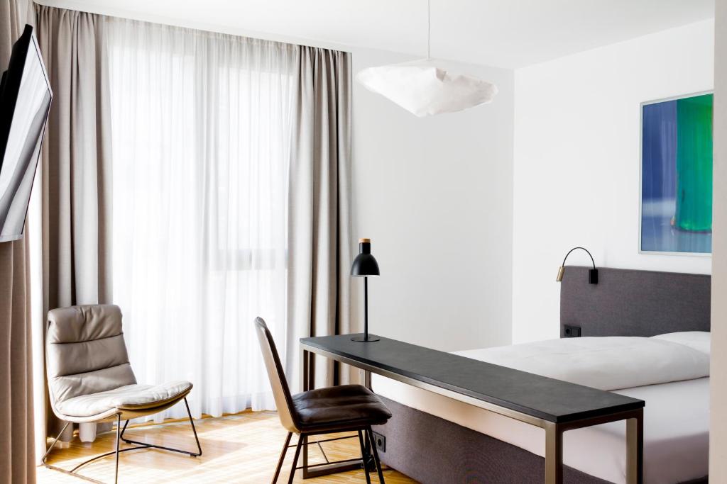 1 Schlafzimmer mit einem Schreibtisch, 2 Stühlen und einem Bett in der Unterkunft Lendhotel in Graz