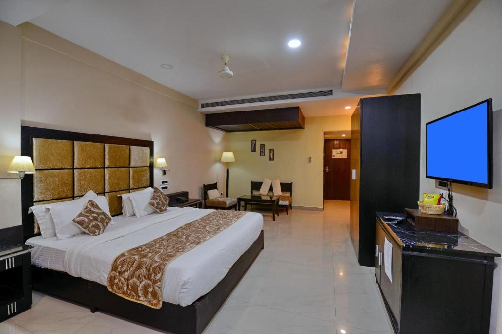 a bedroom with a large bed and a flat screen tv at Hotel Floret Inn in Bhilai