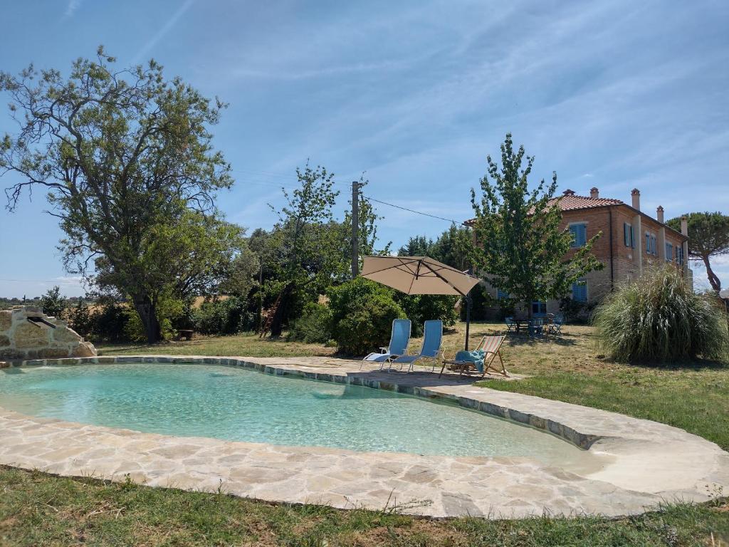 una piscina con 2 sillas y una sombrilla en Casa La Selvella, en Gioiella