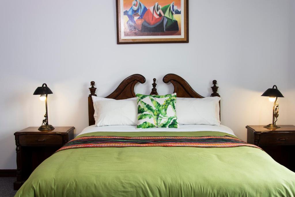 a bedroom with a green bed with two night stands at Inca's Room in La Paz