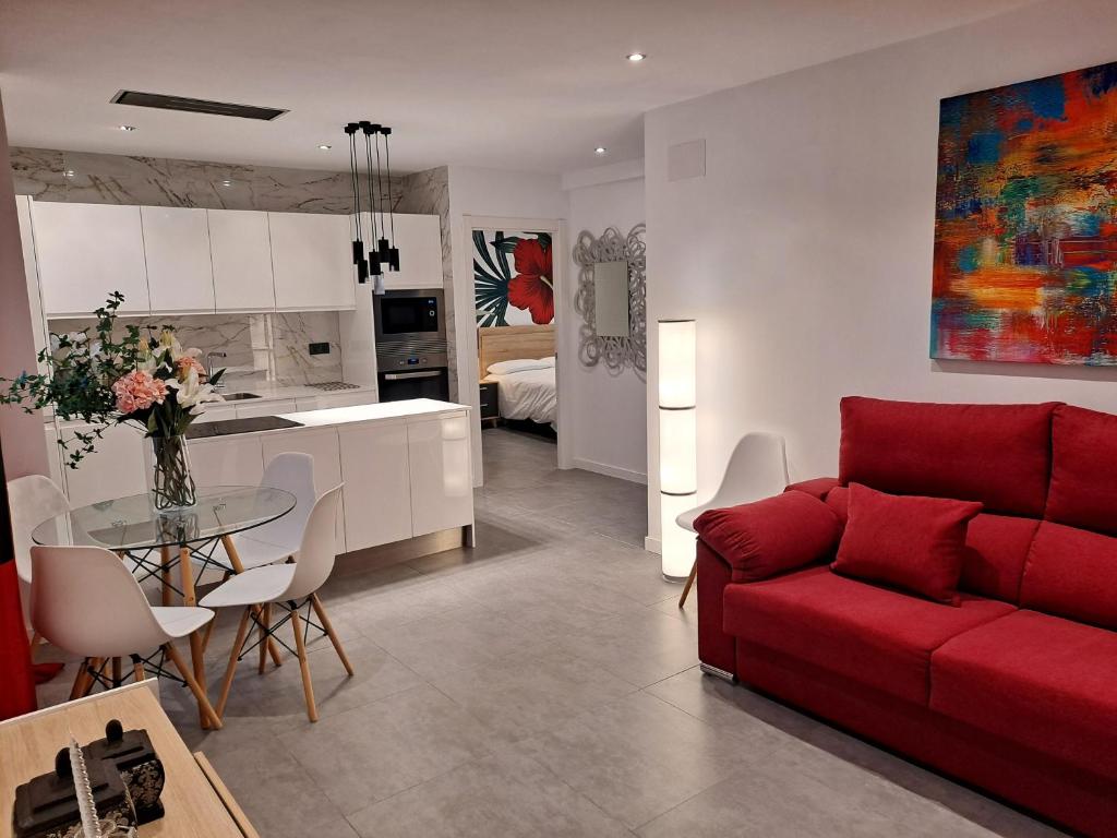 ベニドルムにあるLEVANTE SUITESのリビングルーム(赤いソファ付)、キッチン
