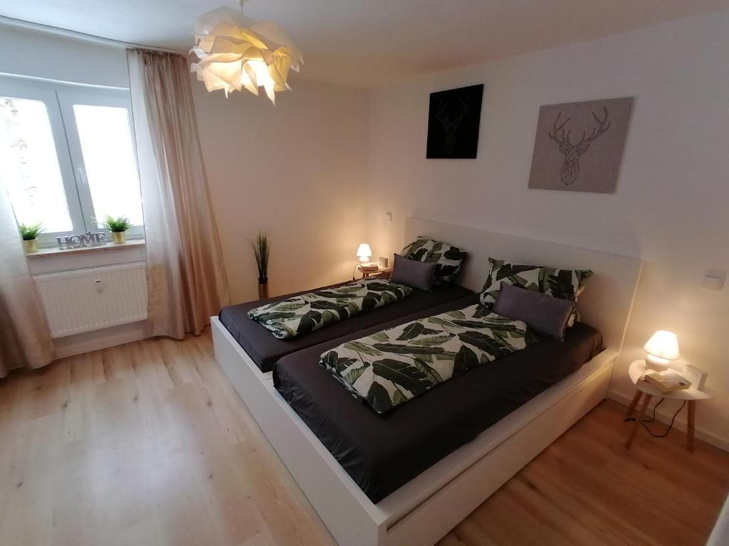 een slaapkamer met 2 bedden en 2 ramen bij Casa Hintze I - 2 Zimmerwohnung Zentrumsnah und Nahe den Bergen in Kempten