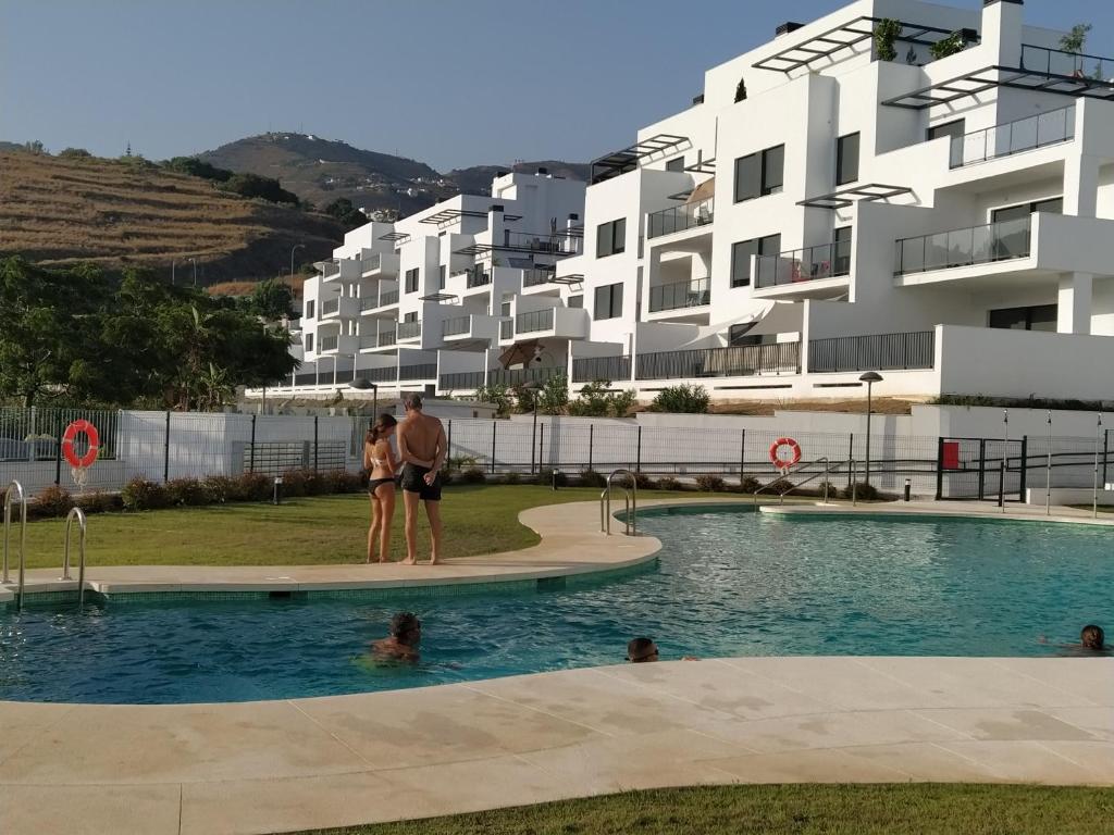un hombre y una mujer de pie en una piscina en urb. costa galera, en Almuñécar