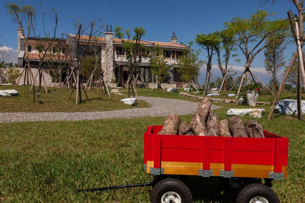 a red truck full of logs in front of a house at Sunnylands B&amp;B 日光小鎮民宿 in Dayin