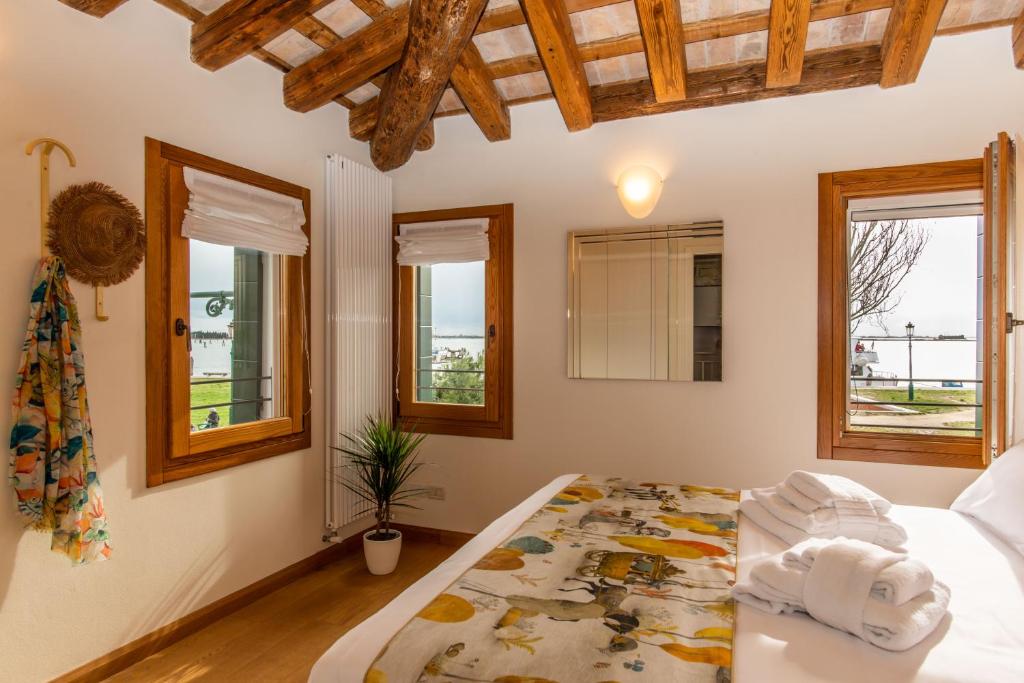 a bedroom with a bed and windows at TIFFANY GOLD in Burano