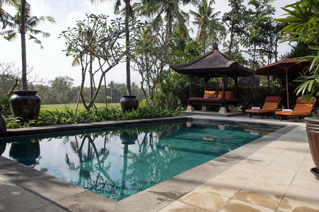 a swimming pool in a resort with a gazebo at Villa Senja in Tanah Lot
