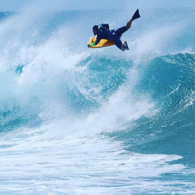 a man riding a wave on a surfboard in the ocean at Vaso Rojo vista mar in Adeje