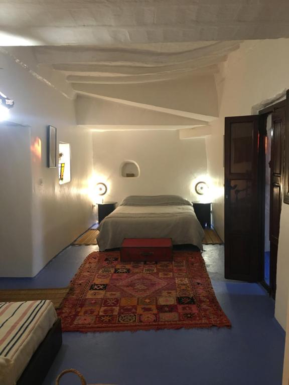 Maison d'hotes Berbari في أصيلة: غرفة نوم بسرير كبير وسجادة