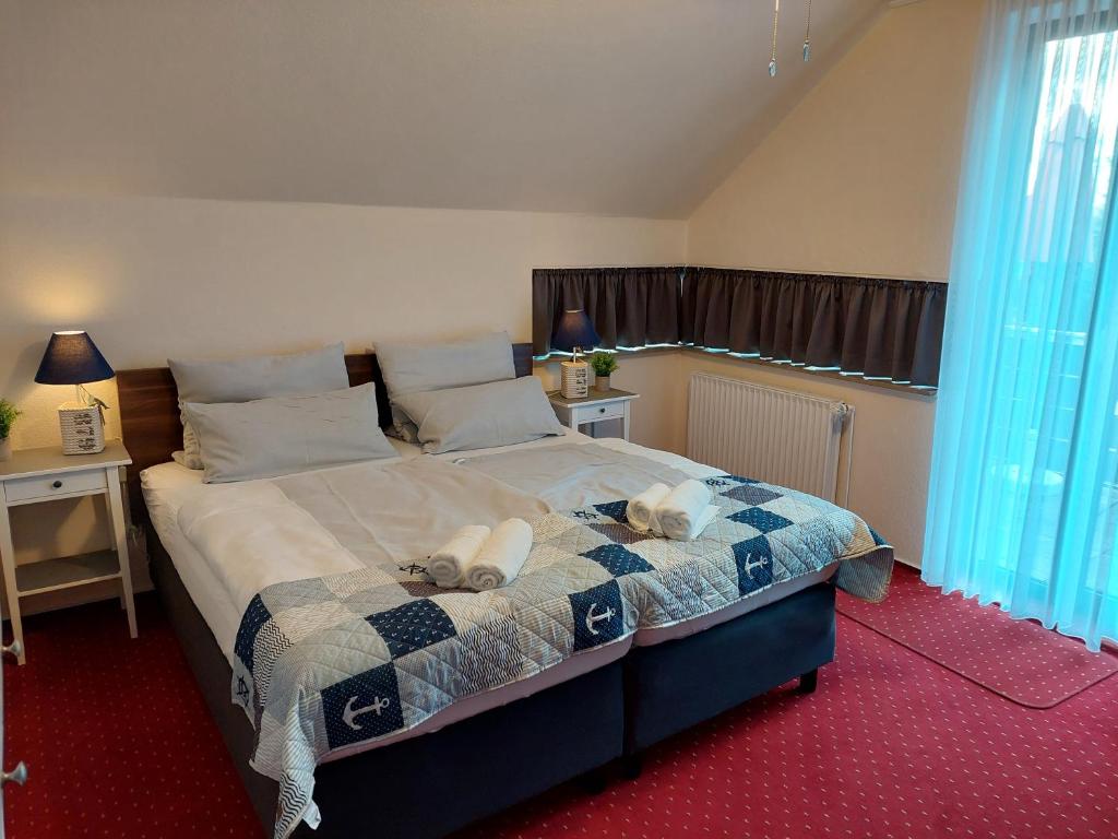 een slaapkamer met een bed met 2 kussens erop bij Hotel Rosmarin in Bad Zwischenahn