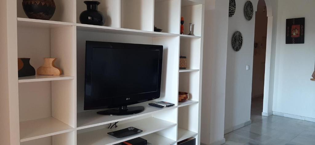 telewizor siedzący na białej półce w salonie w obiekcie Málaga, Mijas, La Cala, apartamento vacaciones de ensueño w mieście La Cala de Mijas