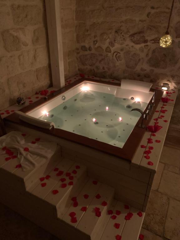 eine Whirlpool-Badewanne in einem Zimmer mit roten Rosen in der Unterkunft Le Vecchie Mura suite & room in Manfredonia