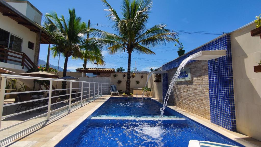 a swimming pool with a water feature in a house at Barreto Hospedagem in Caraguatatuba