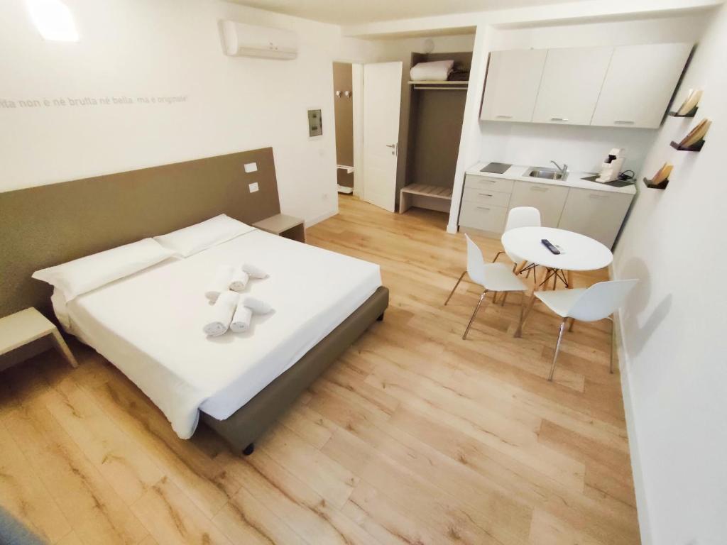 a bedroom with a bed and a table and a kitchen at City Gallery Apartments in Trieste