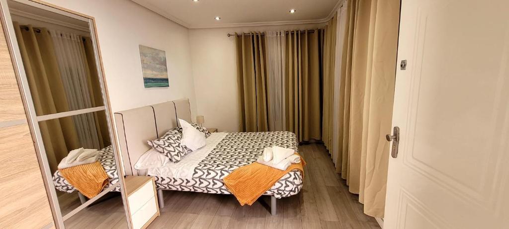 a small bedroom with a bed and a mirror at Hospedaje Puente de Vallecas in Madrid