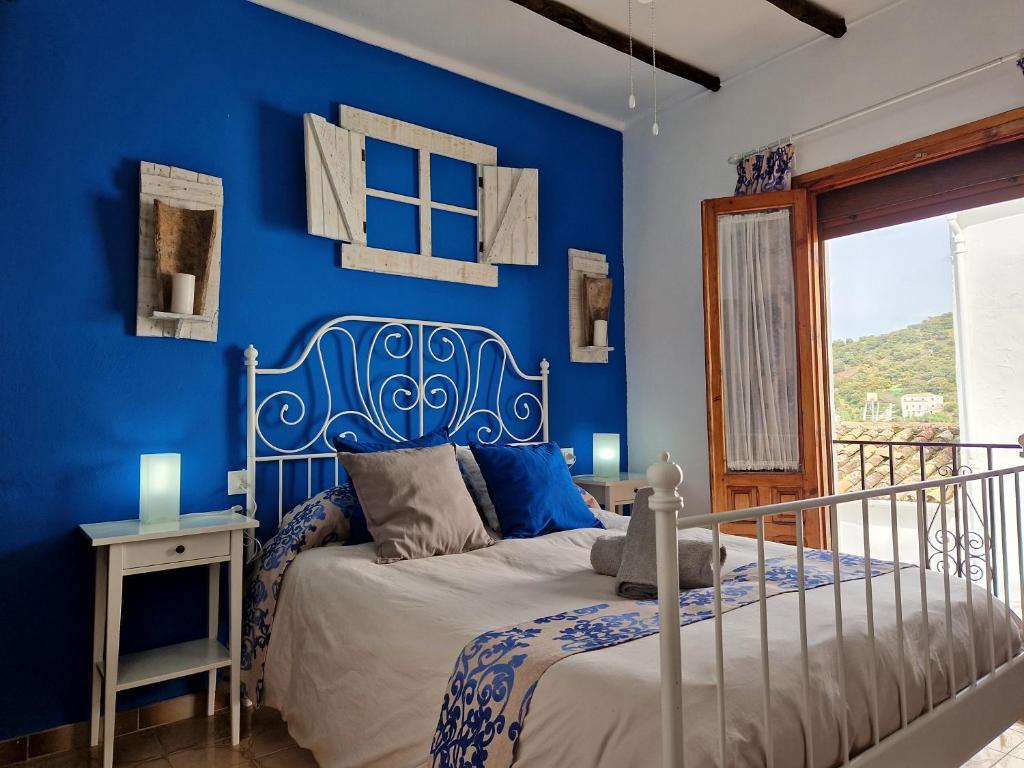 a blue bedroom with a bed and a blue wall at Casa Cuartel in El Gastor