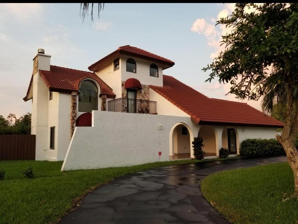 a white house with a red roof and a driveway at Bella Stanza in Miami