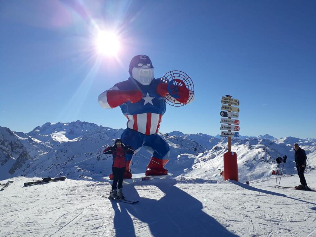 Un uomo in costume da supereroe su una pista da sci di Appartement aux pieds des pistes la tania courchevel a La Perrière