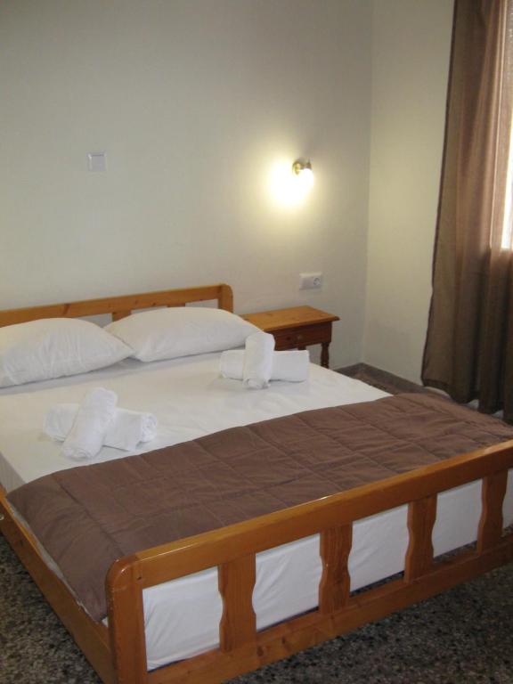 una camera da letto con un grande letto in legno con lenzuola bianche di George house a Theológos